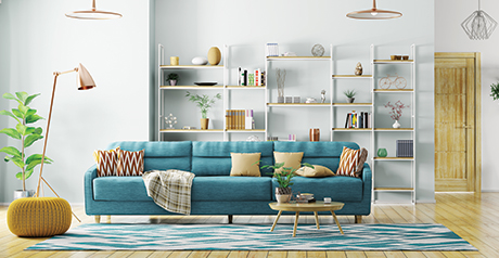 a light and sleek living room with a blue sofa central with shelves in the background